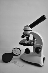 Black and white microscope and magnifying glass on a white background