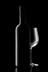 red wine bottle and wine glass isolated on black background