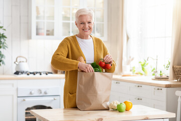 Happy senior woman checking grocery ordered from internet