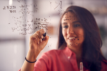 Brainstorming Businesswoman Or Mathematician Drawing Graph Calculation On Glass Screen In Office - obrazy, fototapety, plakaty