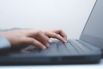 close-up of business woman hand typing and using laptop keyboard for searching with technology networking on working and job on desk at work place or work at home.