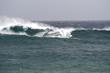 Gigantic waves, jet ski and a surfer