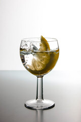 Slice of lemon drops in a glass of water. Water splash in a glass with lemon.