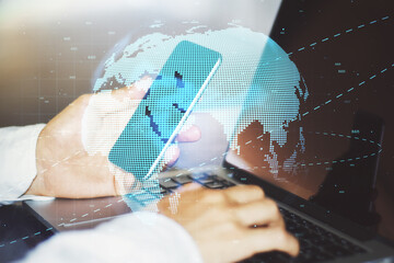 Communication network and blockchain concept with digital world map and businessman typing laptop keyboard with smartphone