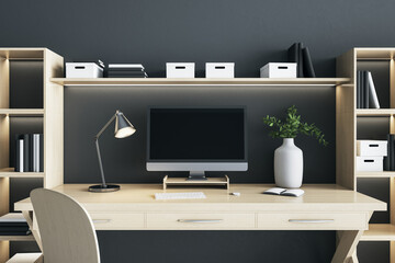 Blank black computer monitor screen with lamp and vase on wooden desk table in eco style interior room. Mock up