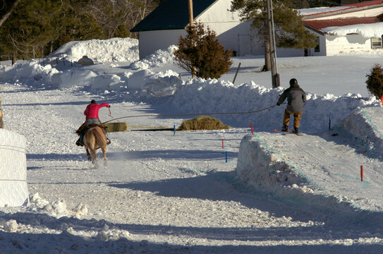 Skijoring: Galloping horse pulls skier so he is airborne over a jump. 