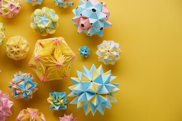 Set of multicolor handmade modular origami balls or Kusudama Isolated on yellow background. Visual...