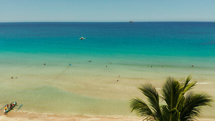 Beautiful tropical beach in cove with blue lagoon and turquoise water. Seascape with sea, sand, palm trees. Nagtabon, Palawan, Philippines. Summer and travel vacation concept