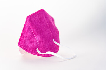 Closeup shot of a pink facial mask isolated on a white background - new normal concept
