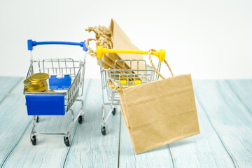 business and finance saving activity with  gold coin arrange in cart with shopping acting and white...