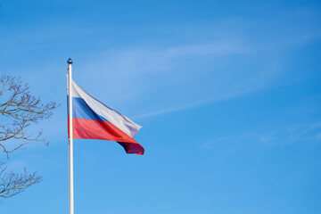 The flag of Russia against the blue sky.
