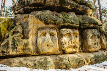 Fototapeta na wymiar Harfenice Natural Formations are large sandstone blocks of sculptures carved into sandstones.Monumental giant heads and other artworks in pine forest near Zelizy village,Czech Republic.Cliff carvings.