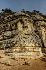 Two giant heads of devils carved into sandstone rocks,each is about 9m high.Devils Heads created by Vaclav Levy near Libechov, Czech republic.Cliff carvings carved in pine forest.Tourist attraction.