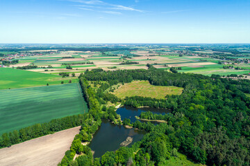 Fototapeta na wymiar Rural landscape with a drone, numerous fields, meadows, forests and water bodies on a sunny summer day. 