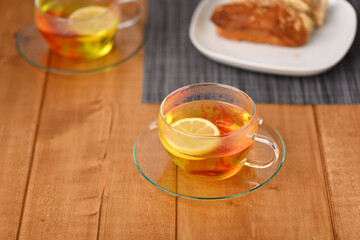 Lemon tea in a glass cup on the wooden table.