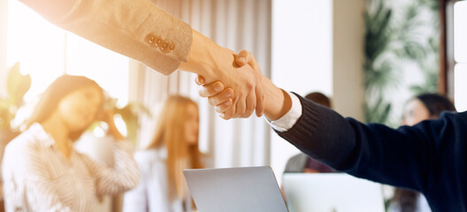Close up view of business partnership handshake. Photo of two businessman handshaking process. Successful deal after great meeting.