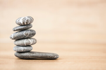 Stone cairn on wood background, simple poise stones, simplicity harmony and balance, rock zen sculptures