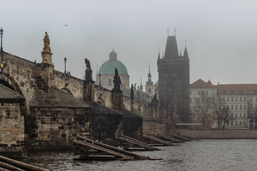 View of Charles bridge, Old Town bridge tower and Vltava River in foggy morning,Prague,Czech Republic.Buildings and landmarks of Old town. Amazing European cityscape.Mystical urban scenery.
