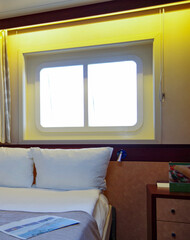 Cozy but dated oceanview cabin or stateroom on classic cruiseship or cruise ship liner with desk,...