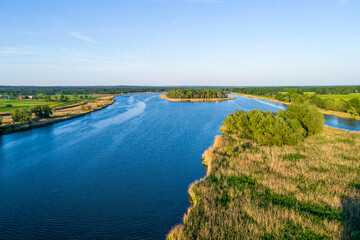 A large river that flows through the countryside. Photo taken during the golden hour.
