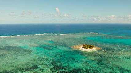 Aerial view of sandy beach with tourists on tropical island with palm trees and turquoise water....