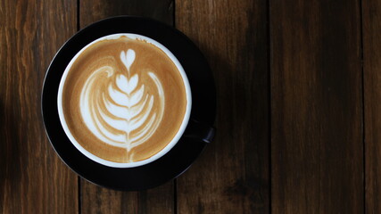 Coffee cup of cappuccino with latte art on wooden and Copy space