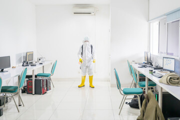 Worker clean office interior with disinfectant spray