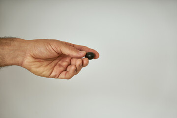 Fototapeta premium Man's hands show black olive just picked from the olive tree