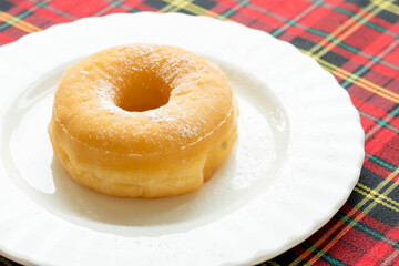 Glazed donuts on a white plate On the ceiling tabs with red patterns