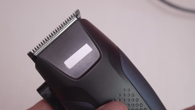 hair clipper works,turn on the button on the clipper close up, knives cutting hair