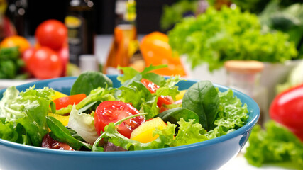 Fresh salad with lettuce leaves and tomato in bowl