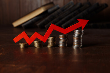 Red up arrow and stacks of gold coins.