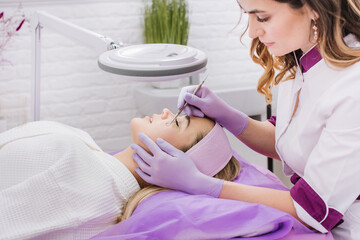Young woman takes SPA tratments with beautician in the beauty salon