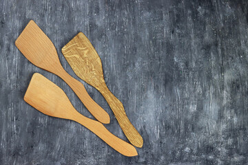 Wooden kitchen spatulas isolated on gray background