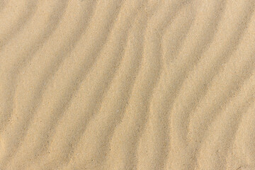 Fototapeta na wymiar Natural sand stone texture background. sand on the beach as background. Wavy sand background for summer designs.