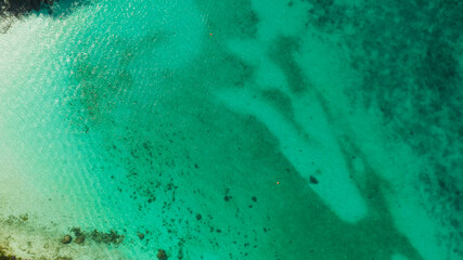 Sea water surface in lagoon, background with sun light reflection, copy space for text, aerial view. Top view transparent turquoise ocean water surface. background texture