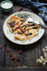 crepes in a white plate thin pancakes pour chocolate syrup flat cake Shrovetide snack healthy meal top view copy space for text food background rustic