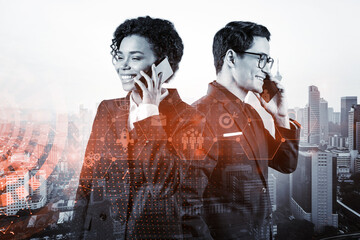 Two colleagues in multinational corporate team processing call new tech approaches to solve problems at research and development department. Fintech hologram icons over Kuala Lumpur