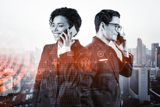 Two colleagues in multinational corporate team processing call new tech approaches to solve problems at research and development department. Fintech hologram icons over Kuala Lumpur