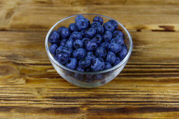 Fresh blueberry in glass bowl on a wooden table