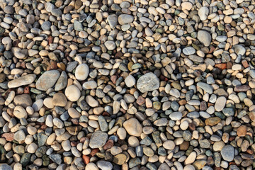 Smooth round pebbles texture background. Pebble sea beach close-up