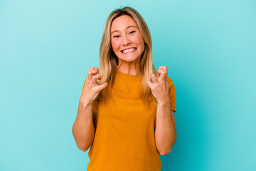 Young mixed race woman isolated on blue background upset screaming with tense hands.