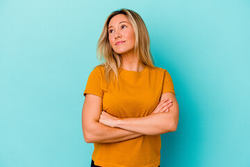 Young mixed race woman isolated on blue background dreaming of achieving goals and purposes