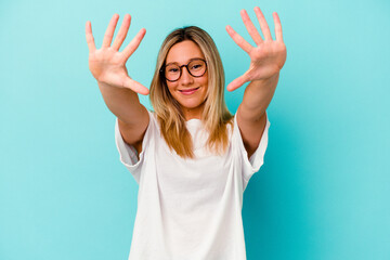 Young mixed race woman isolated on blue background showing number ten with hands.
