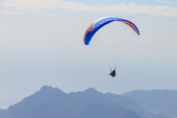 Paragliders flying from a top of Tahtali mountain near Kemer, Antalya Province in Turkey. Concept of active lifestyle and extreme sport adventure