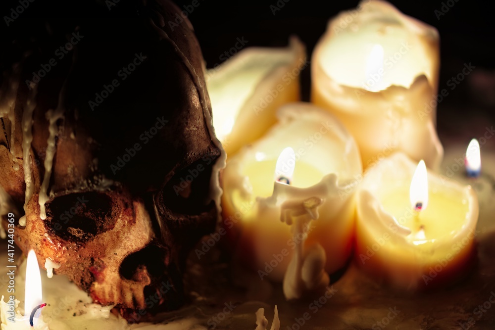 Wall mural Human skull against dark background in candle light closeup