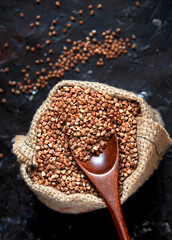 buckwheat groats in burlap sack on dark background