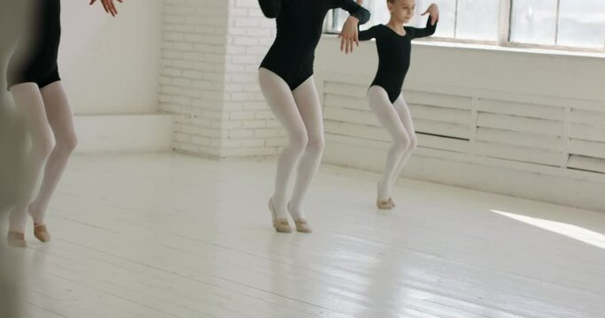 Three teen girls wearing leotards, performing during a dance class. Kids having a rehearsal session in white hall - arts, childhood dream 4k footage
