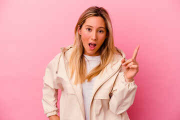 Young mixed race woman isolated on pink background having an idea, inspiration concept.