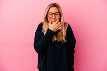 Young mixed race woman isolated on pink background doubting between two options.